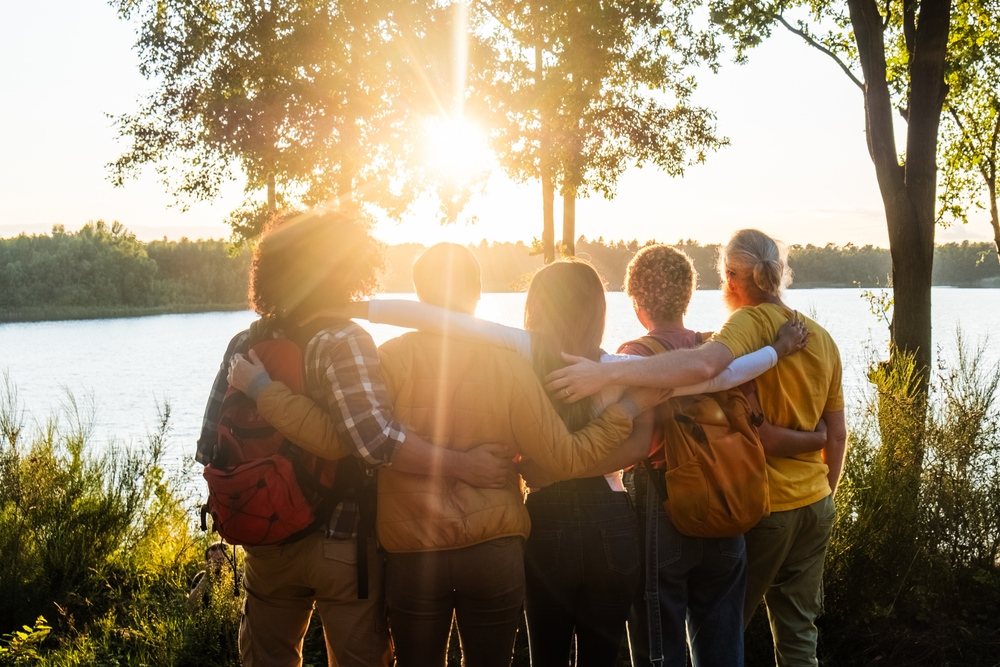 This,Heartwarming,Image,Showcases,A,Group,Of,Friends,,Arms,Around group of friends enjoying a day on the lake watching the sunset